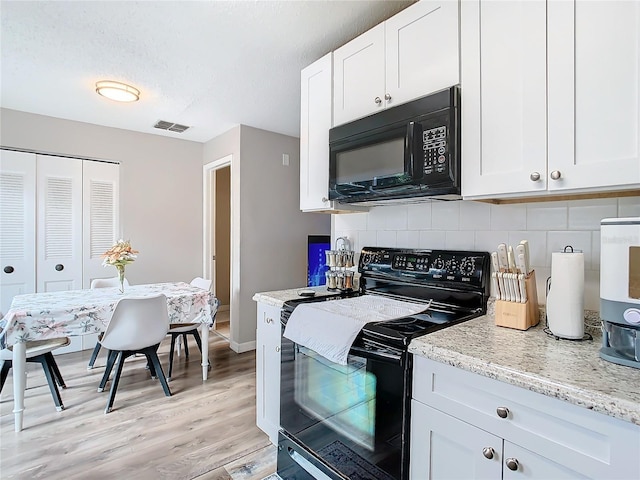 kitchen with white cabinetry, backsplash, light stone counters, and black appliances