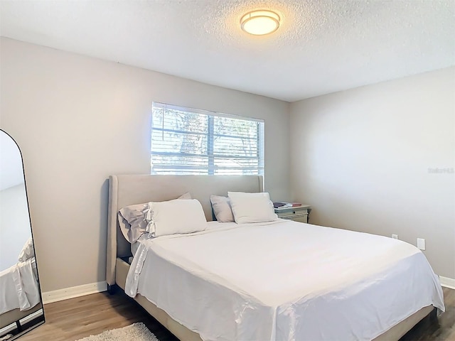 bedroom with hardwood / wood-style flooring and a textured ceiling