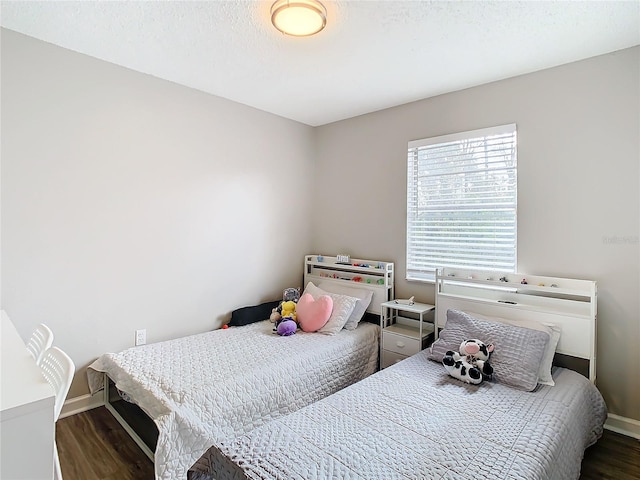 bedroom with dark hardwood / wood-style flooring and a textured ceiling