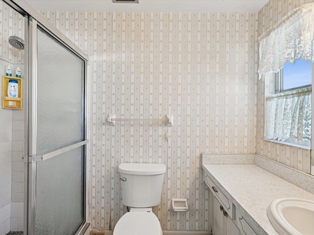 bathroom featuring vanity, toilet, and an enclosed shower