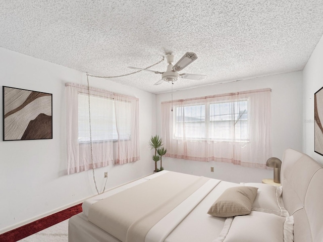 bedroom featuring ceiling fan, carpet, and a textured ceiling