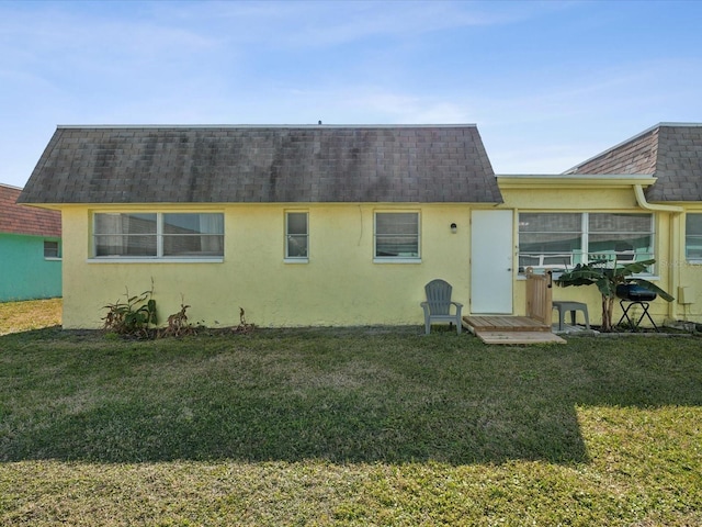 rear view of property featuring a lawn