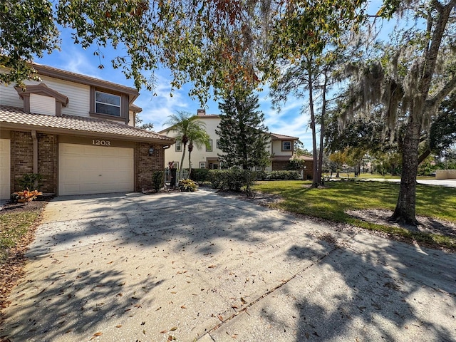 1203 Clays Trl Unit 406, Oldsmar, FL 34677 - view of front of house featuring concrete driveway, a tile roof, an attached garage, a front lawn, and brick siding