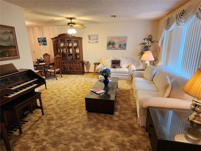 carpeted living room with ceiling fan and a textured ceiling