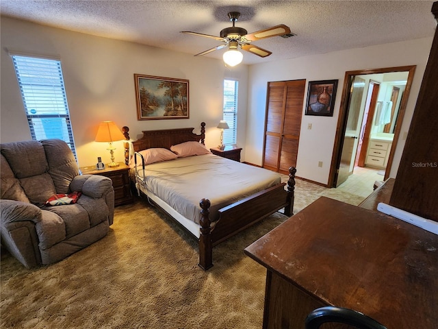 bedroom featuring ceiling fan, ensuite bathroom, carpet floors, a textured ceiling, and a closet