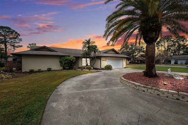 view of front of home with a garage and a yard