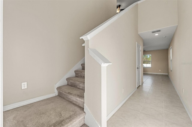 staircase featuring tile patterned flooring