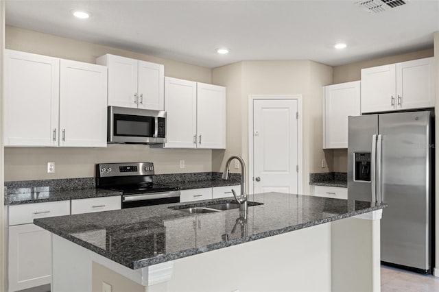 kitchen featuring white cabinetry, appliances with stainless steel finishes, sink, and a center island with sink