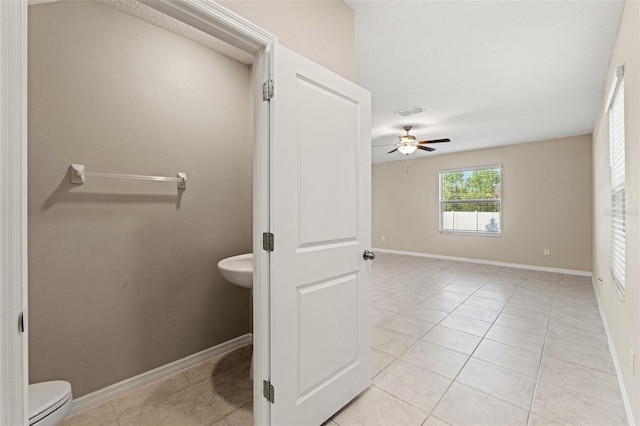 bathroom featuring ceiling fan, tile patterned floors, and toilet