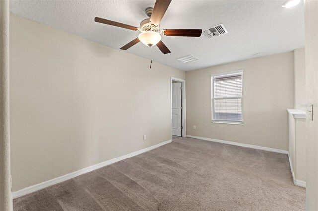 carpeted spare room with ceiling fan and a textured ceiling