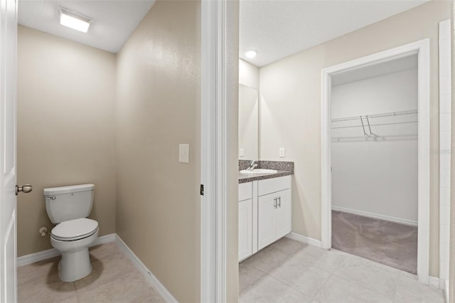 bathroom featuring tile patterned floors, toilet, and vanity