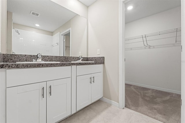 bathroom with vanity and a tile shower