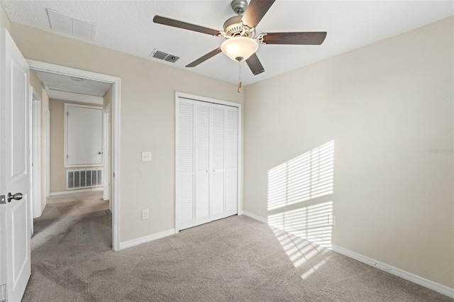 unfurnished bedroom featuring ceiling fan, a closet, and light carpet