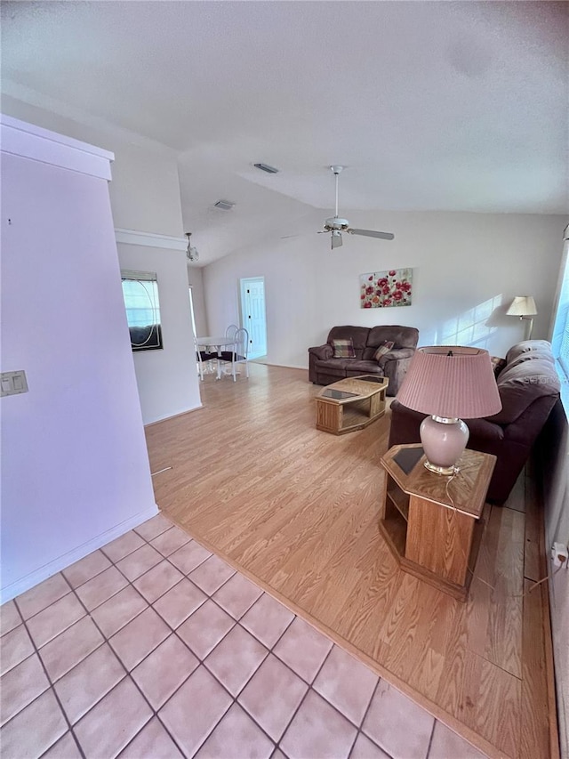 living room featuring lofted ceiling, a textured ceiling, ceiling fan, and light wood-type flooring