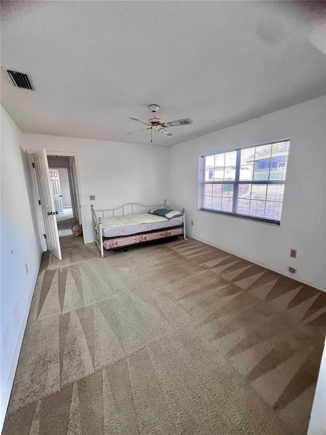 unfurnished bedroom with light carpet and ceiling fan