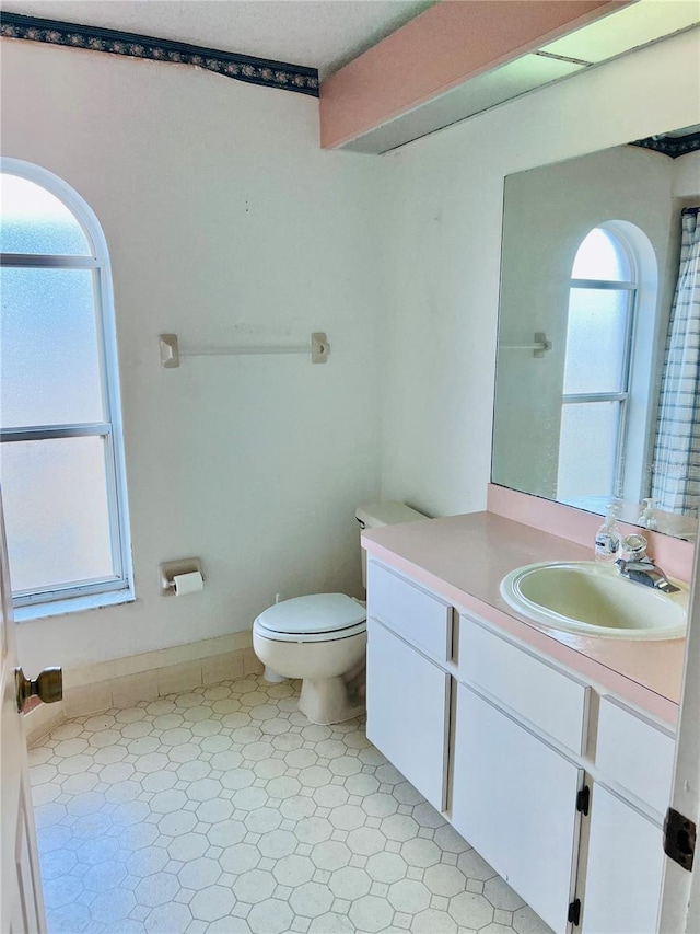 bathroom with vanity, a wealth of natural light, and toilet