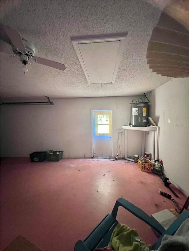 basement featuring water heater and a textured ceiling