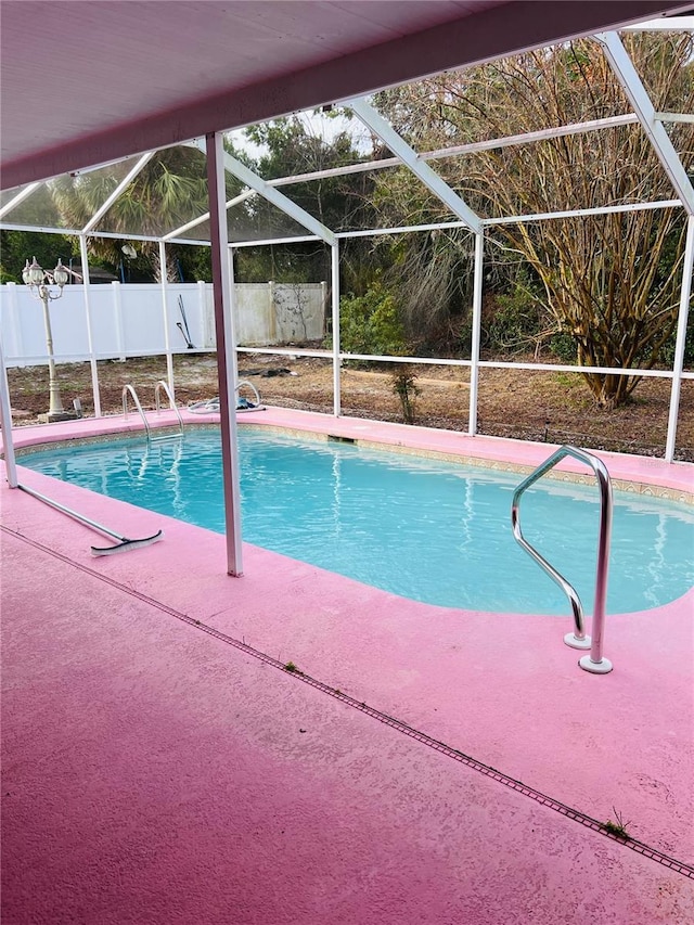 view of swimming pool with glass enclosure and a patio area