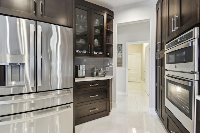 kitchen with tasteful backsplash, stainless steel appliances, and dark brown cabinetry