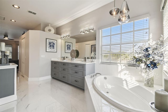 bathroom featuring vanity, a relaxing tiled tub, and ceiling fan