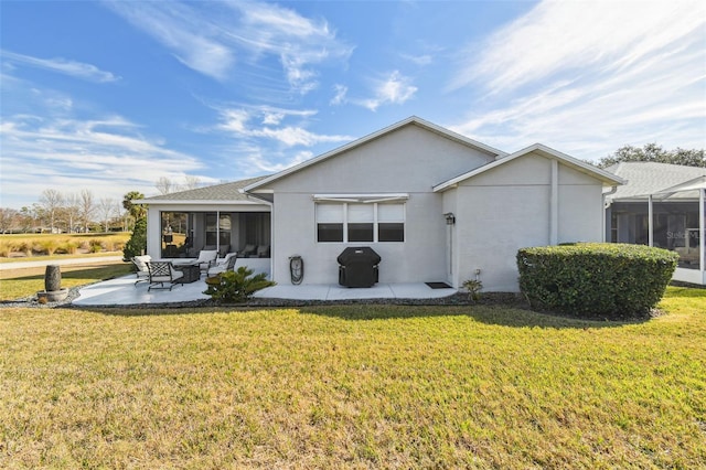 back of property featuring a lawn, a sunroom, and a patio