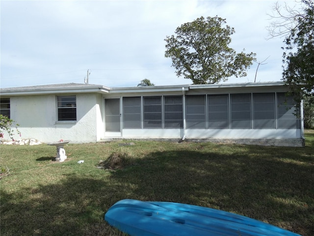 13737 Michelle Ave, Hudson, FL 34667 - back of property featuring a sunroom, stucco siding, and a lawn