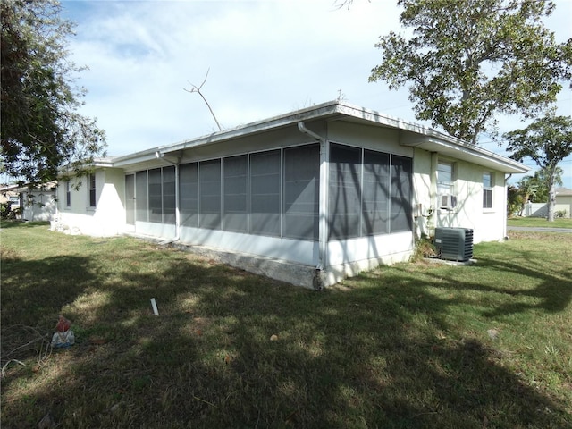 13737 Michelle Ave, Hudson, FL 34667 - view of side of home with a sunroom, a lawn, and stucco siding