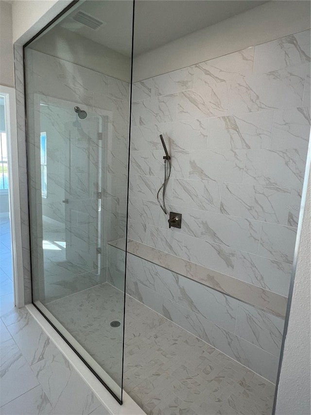 full bathroom featuring marble finish floor and a marble finish shower