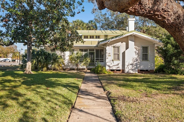 view of front of property featuring a front yard and a sunroom