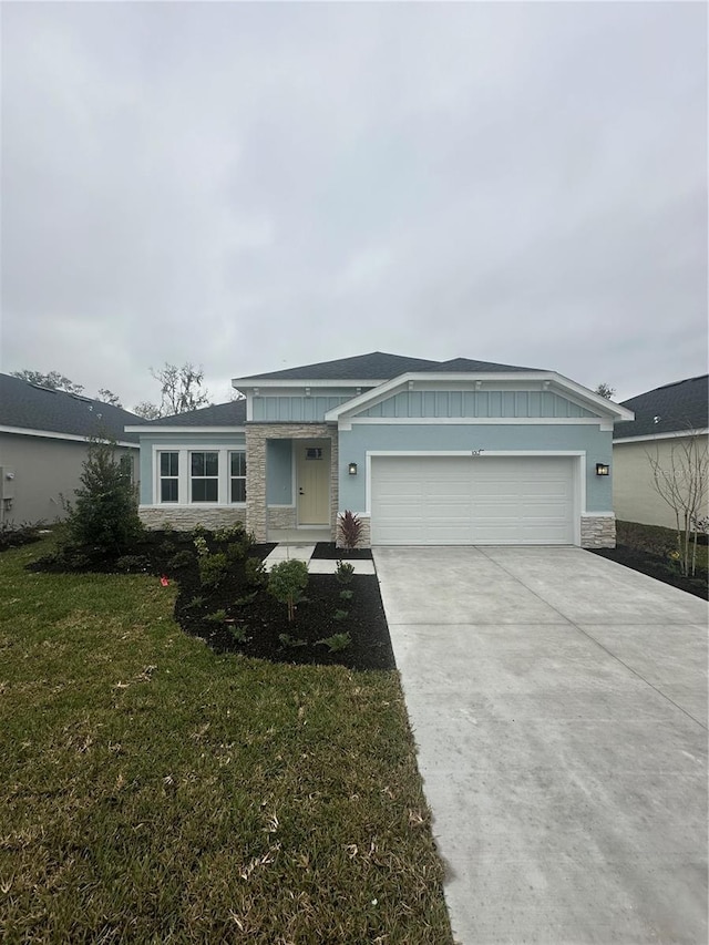 single story home featuring a garage and a front lawn