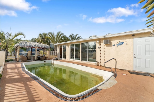 view of swimming pool featuring a gazebo, a wall unit AC, and a patio