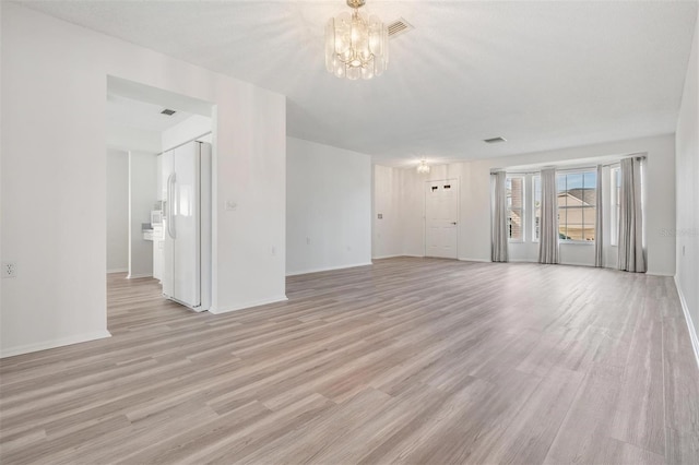 unfurnished living room with light hardwood / wood-style floors and a notable chandelier