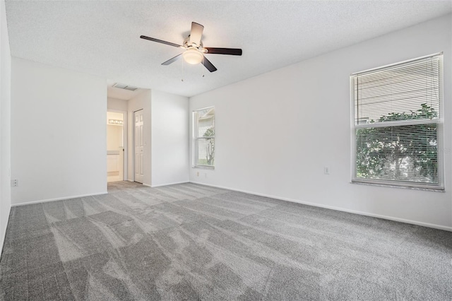 carpeted empty room featuring ceiling fan and a textured ceiling