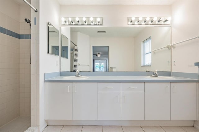 bathroom featuring ceiling fan, vanity, tile patterned flooring, and a tile shower