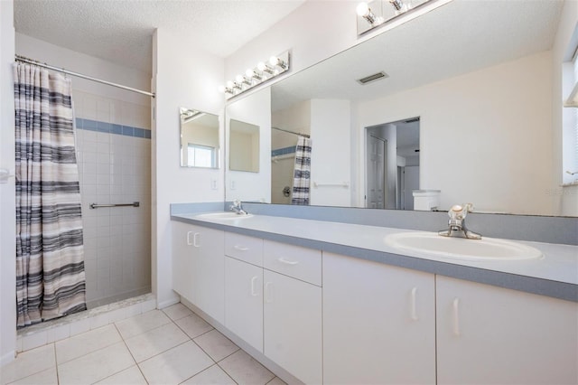 bathroom featuring tile patterned floors, vanity, a shower with shower curtain, and a textured ceiling