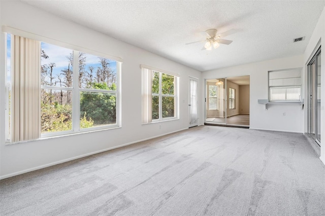 unfurnished living room with ceiling fan, a textured ceiling, and carpet