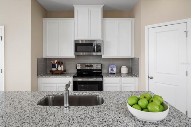 kitchen featuring white cabinetry, decorative backsplash, and appliances with stainless steel finishes