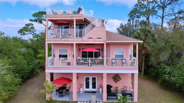 back of property featuring a balcony, a patio area, and french doors