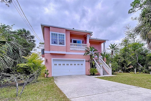 view of front of home featuring a garage, a front yard, and a balcony