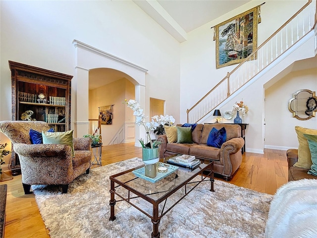 living room featuring high vaulted ceiling and light hardwood / wood-style floors