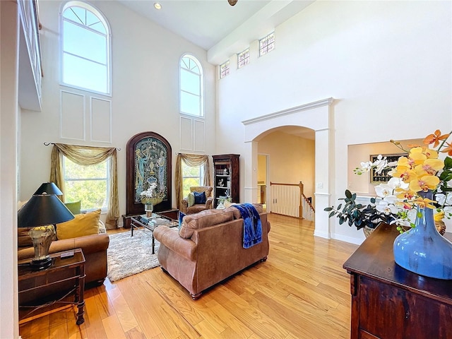 living room with light hardwood / wood-style floors and a high ceiling