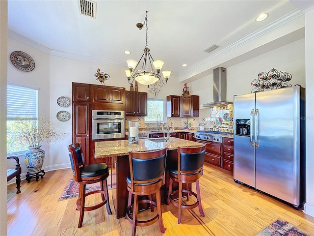 kitchen featuring a kitchen island, appliances with stainless steel finishes, a breakfast bar, range hood, and sink