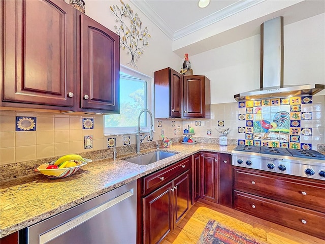 kitchen with appliances with stainless steel finishes, sink, ornamental molding, light stone countertops, and wall chimney range hood