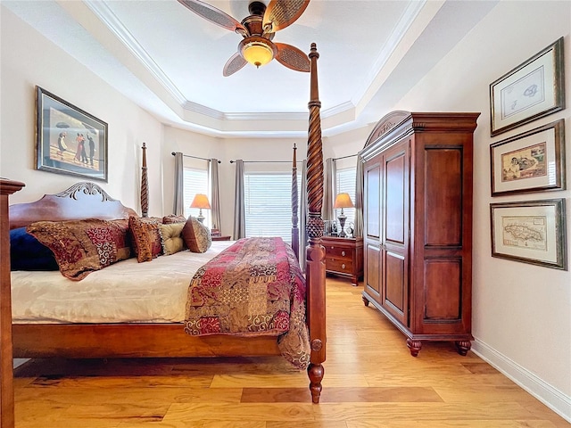 bedroom featuring ornamental molding, ceiling fan, light hardwood / wood-style floors, and a tray ceiling