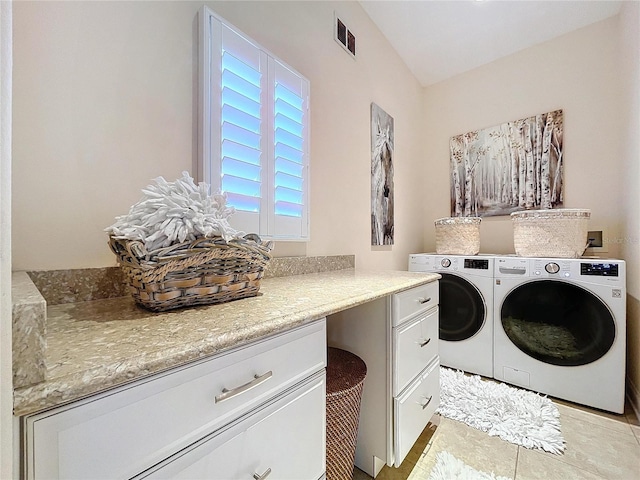 laundry area with cabinets, washing machine and clothes dryer, and light tile patterned floors