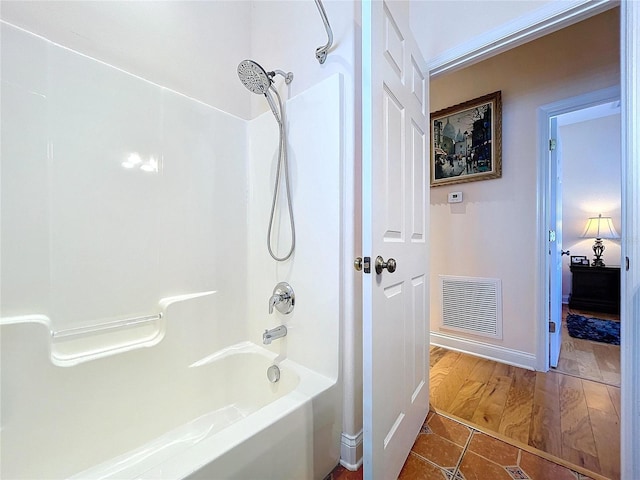 bathroom featuring tile patterned floors and bathing tub / shower combination