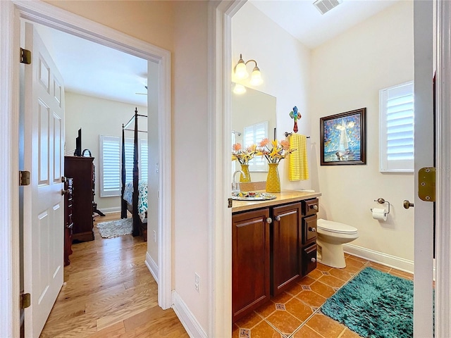 bathroom with hardwood / wood-style flooring, vanity, and toilet