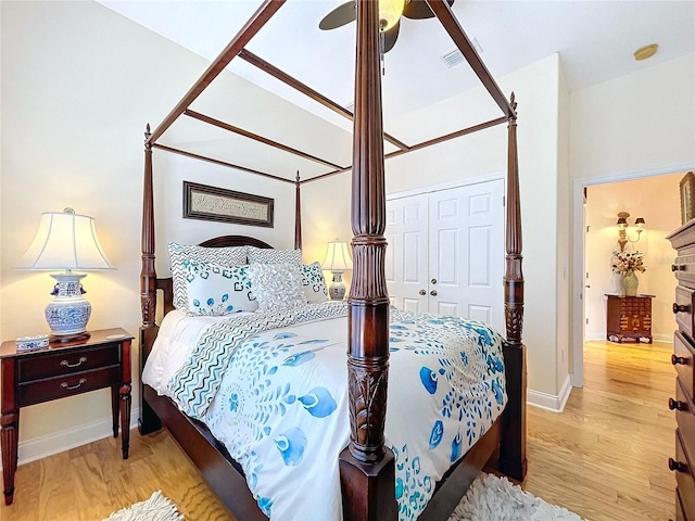 bedroom featuring ceiling fan, a closet, and light wood-type flooring