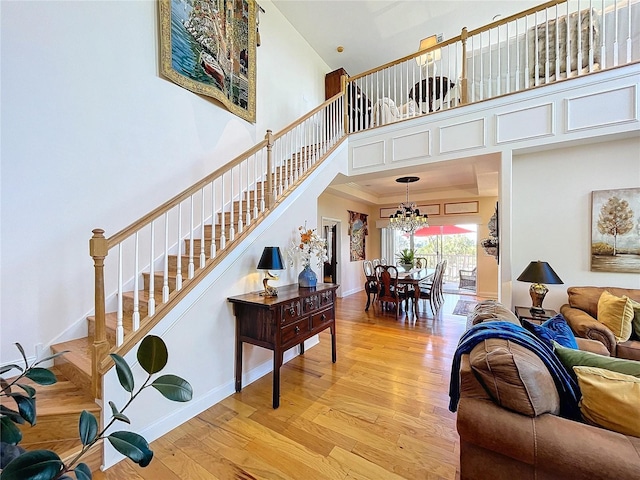 stairs featuring a high ceiling, hardwood / wood-style flooring, and a chandelier