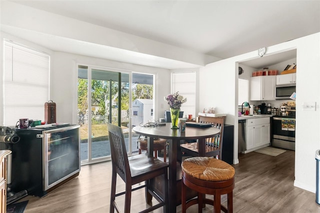 dining room with sink, dark wood-type flooring, and vaulted ceiling